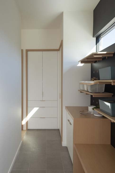 Statement pegboard drop zone with adjustable recessed wood pegs in the Affogato mud room, Edmonton