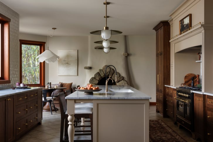 Plastered wood-burning fireplace with an exposed stone hearth in a Nelson kitchen renovation