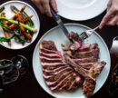 Someone cutting into a steak at Elisa Steakhouse
