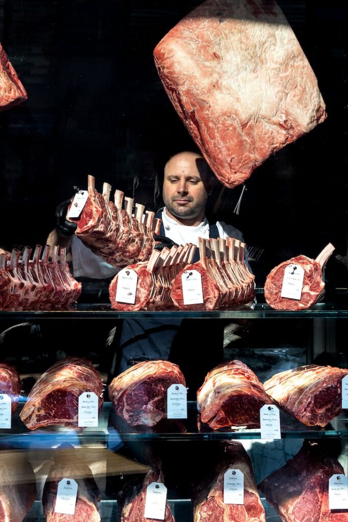 Head butcher Brett Vilcu arranging steaks at Luigi & Sons