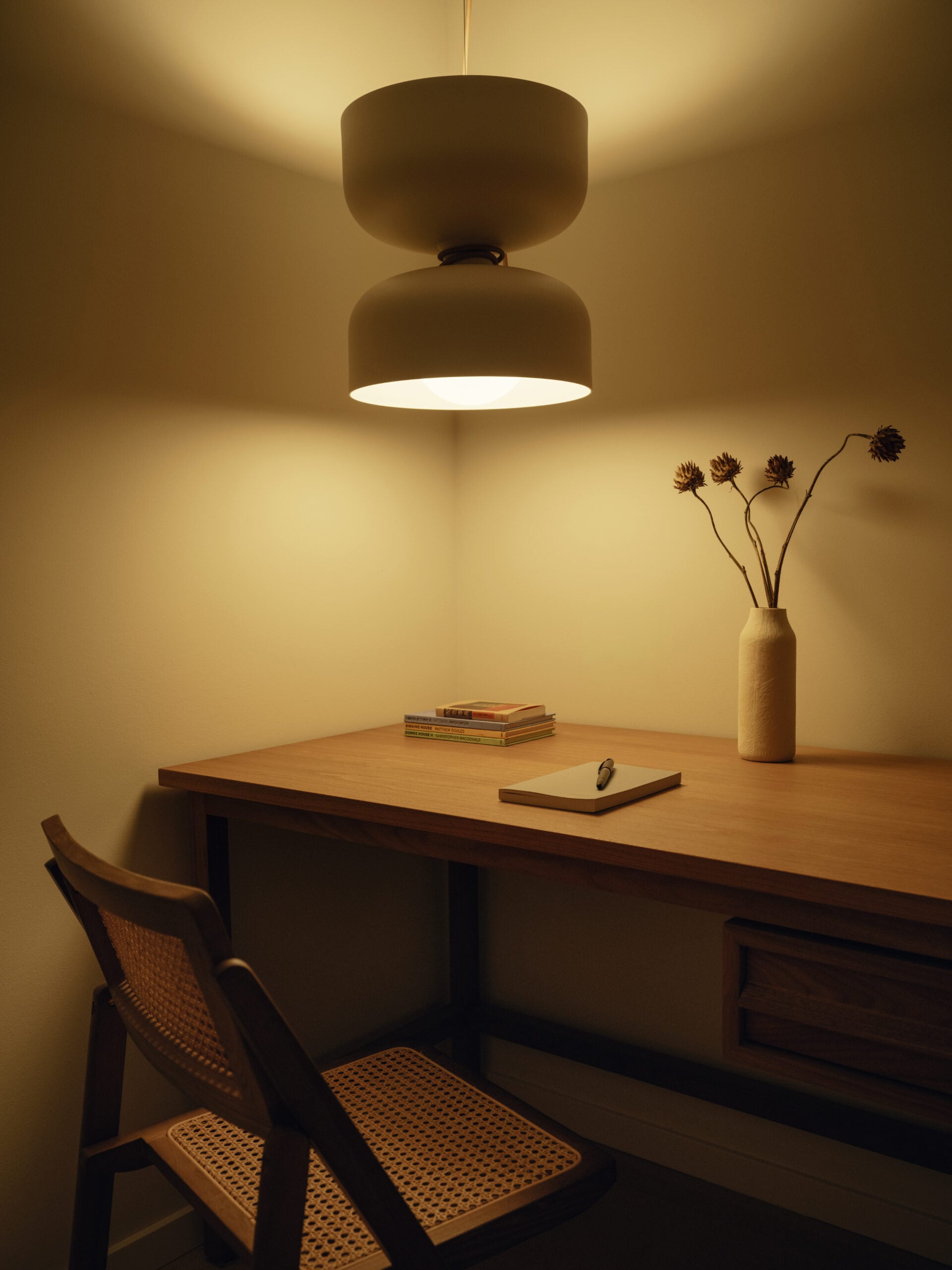Small office with wood desk, chair and pendant light