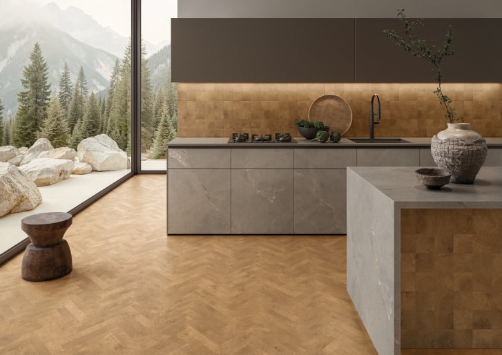 Modern kitchen with warm wood-toned flooring and textured porcelain tile from Ames Tile