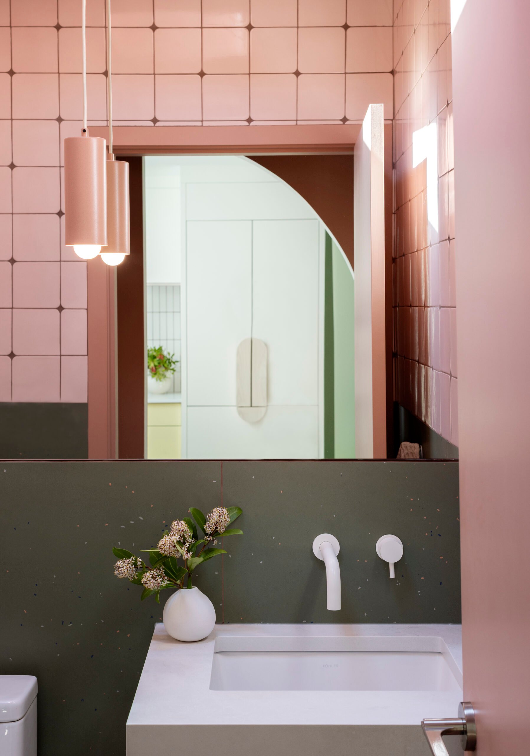 Tile wrapping the walls and ceiling in the Little Mountain powder room by Pure Design Inc.