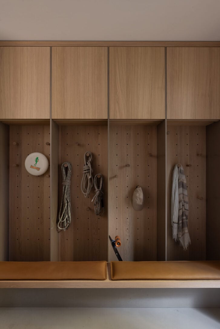 Expanded laundry and mud room with drying closets and warm oak millwork by Falken Reynolds