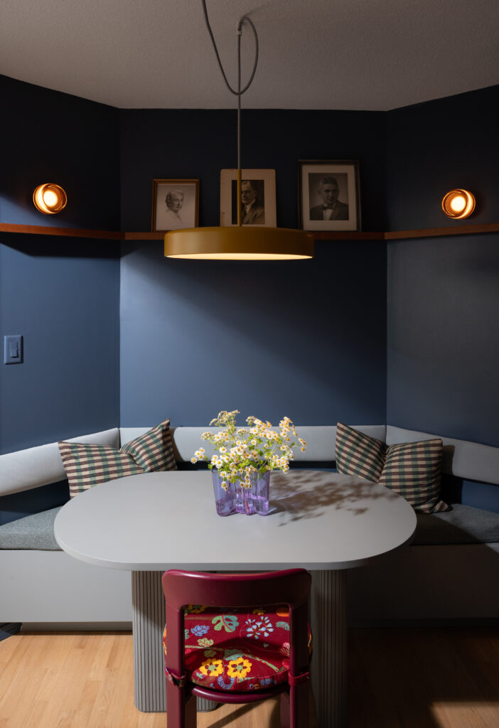 parlour nook with blue painted walls, banquette seating, and dining table
