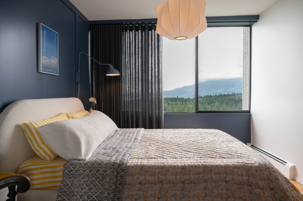 bedroom view with blue walls, wall moulding, and patterned bedding