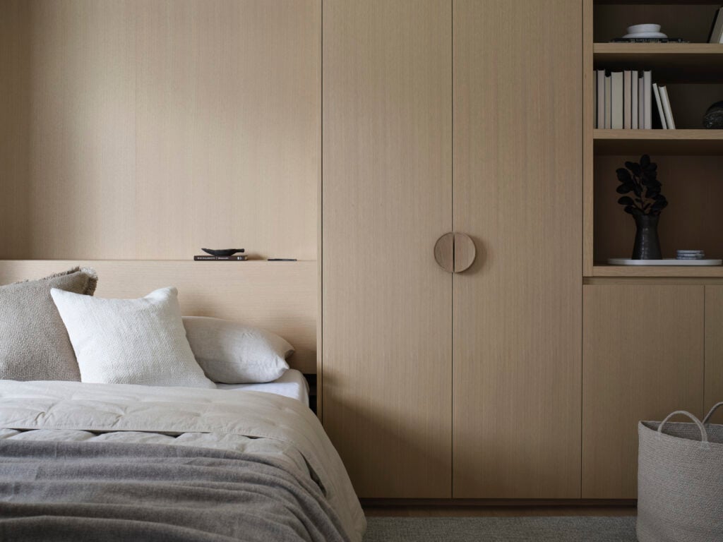 Light wood millwork with built-in storage beside a pulled-down Murphy bed