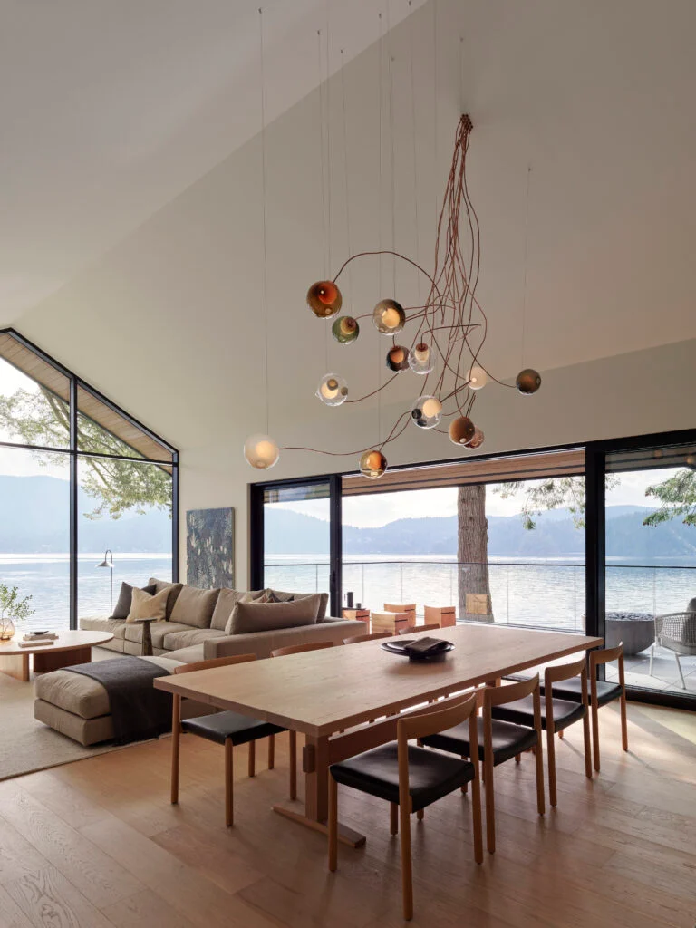 Dining room with Bocci pendant lights and long wood table with ocean views in the background