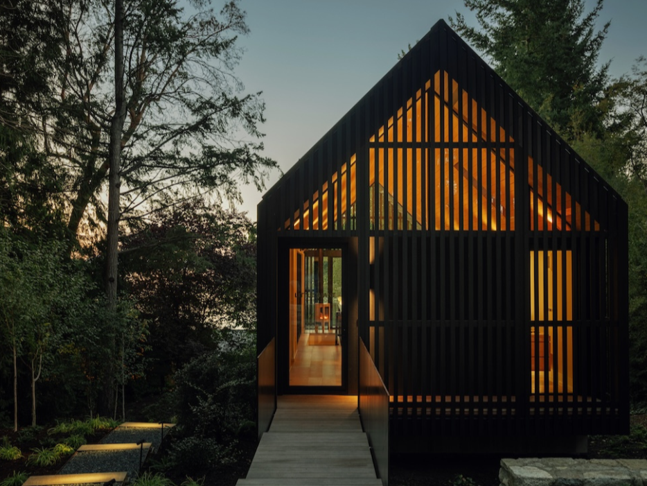 Cedar-clad studio with elevated walkway on a forested site