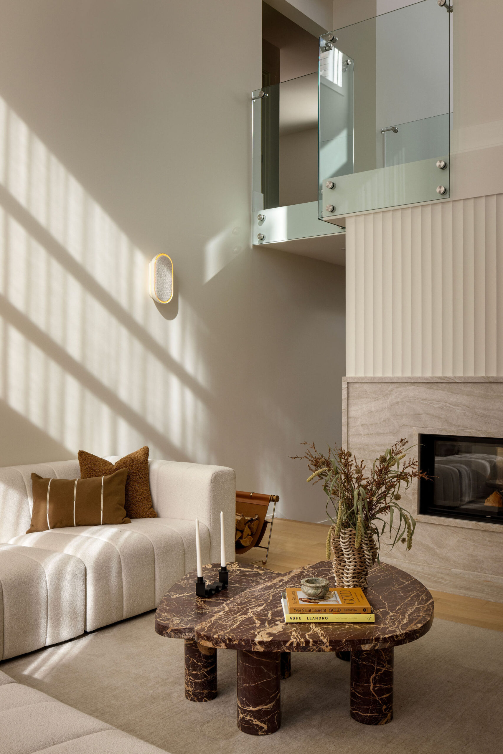 Living room with cream sofa, marble coffee table and two-storey fireplace
