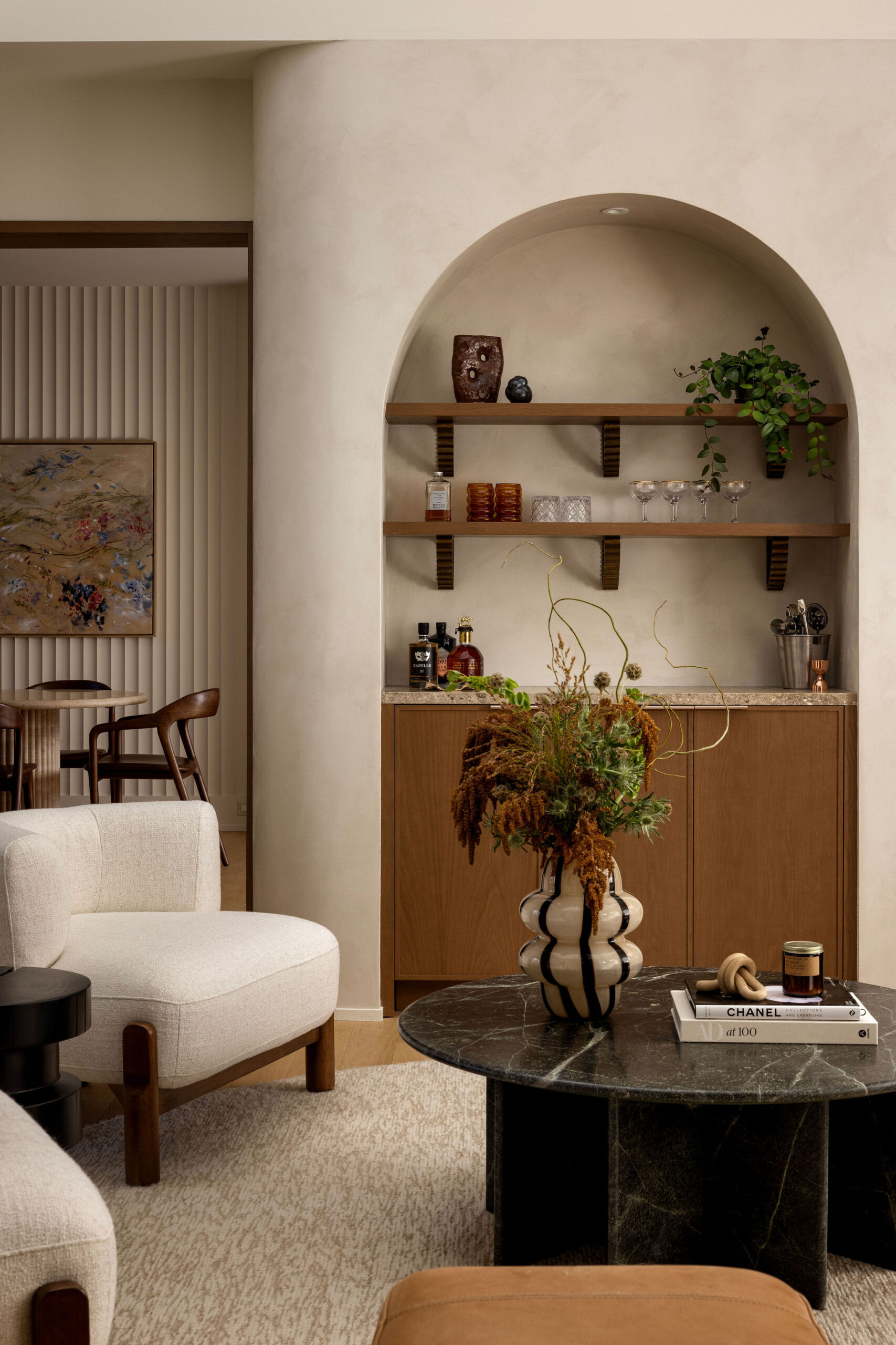 Lounge area with arched built-in shelving and round marble coffee table