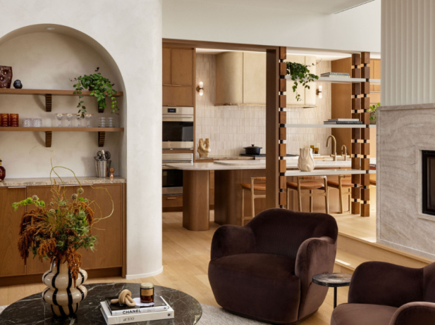 Lounge area with arched built-in shelving and bar, marble coffee table and dark brown armchairs