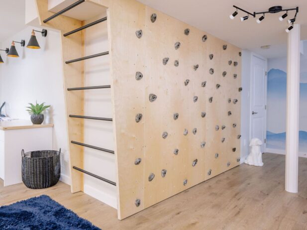 Monkey bars and a climbing wall inside of a basement bedroom.