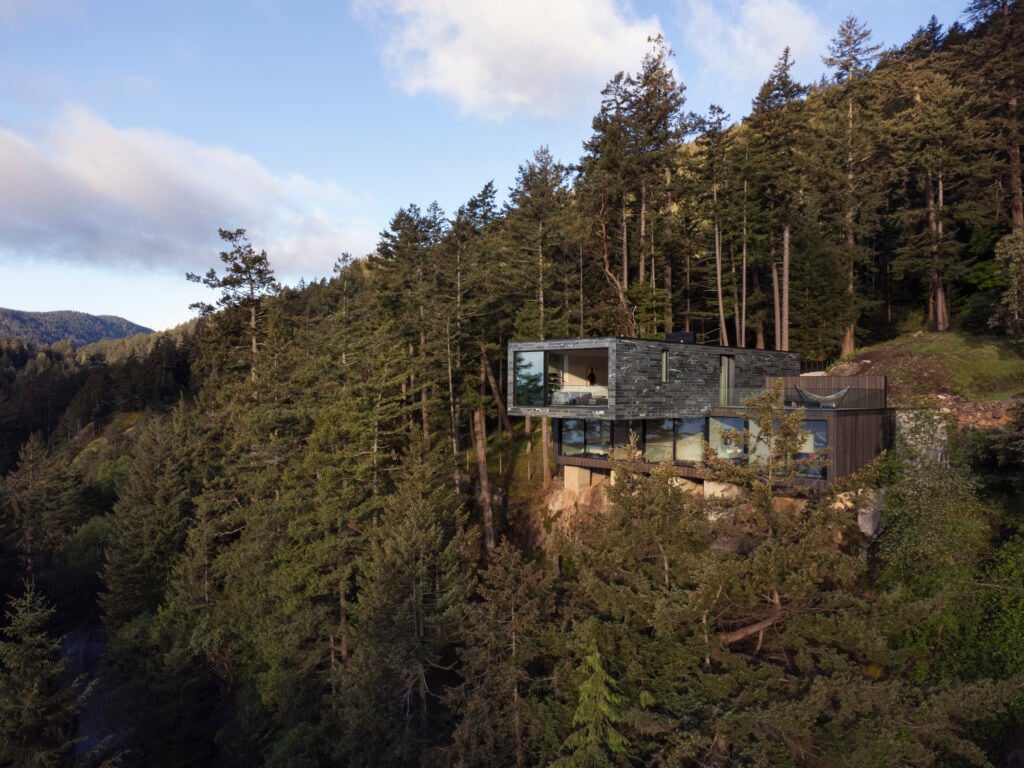 Modern cantlievered home built on Bowen Island cliffside, surrounded by trees