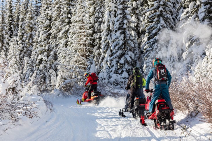 Snowmobiler riding a groomed trail through the mountains near Golden, British Columbia
