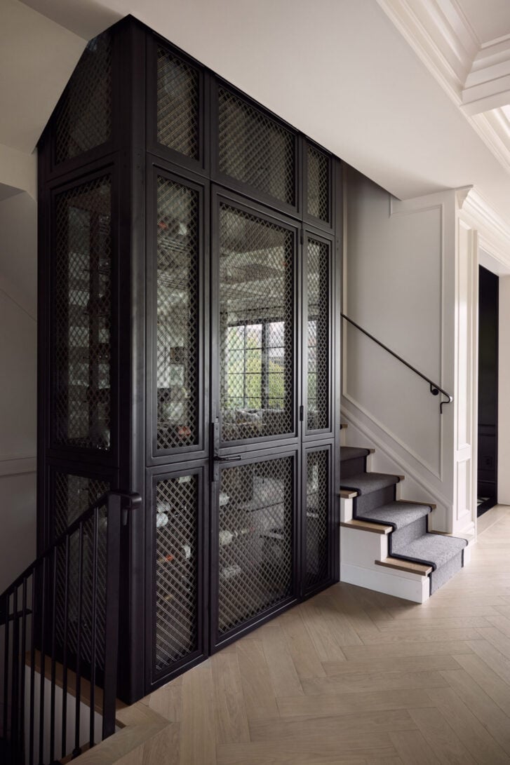 Elevator-inspired wine tower beside the stairs in the Kits Point wine cellar, Vancouver
