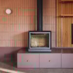 tiled fireplace wall with black stove and built-in purple cabinetry