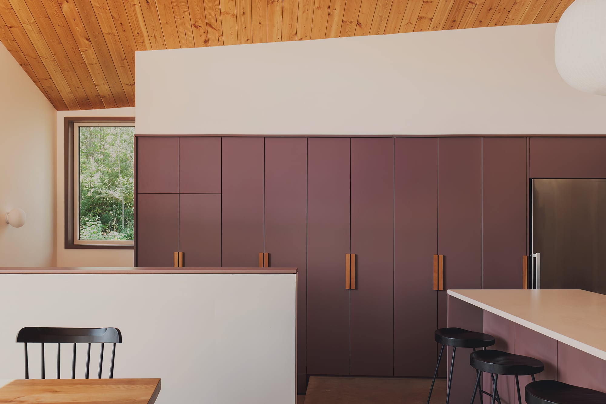 built-in purple cabinetry and kitchen island beneath wood ceiling