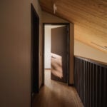 upper floor hallway with wood floor, railing and sloped ceiling