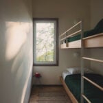 bedroom with wood bunk beds and tall window