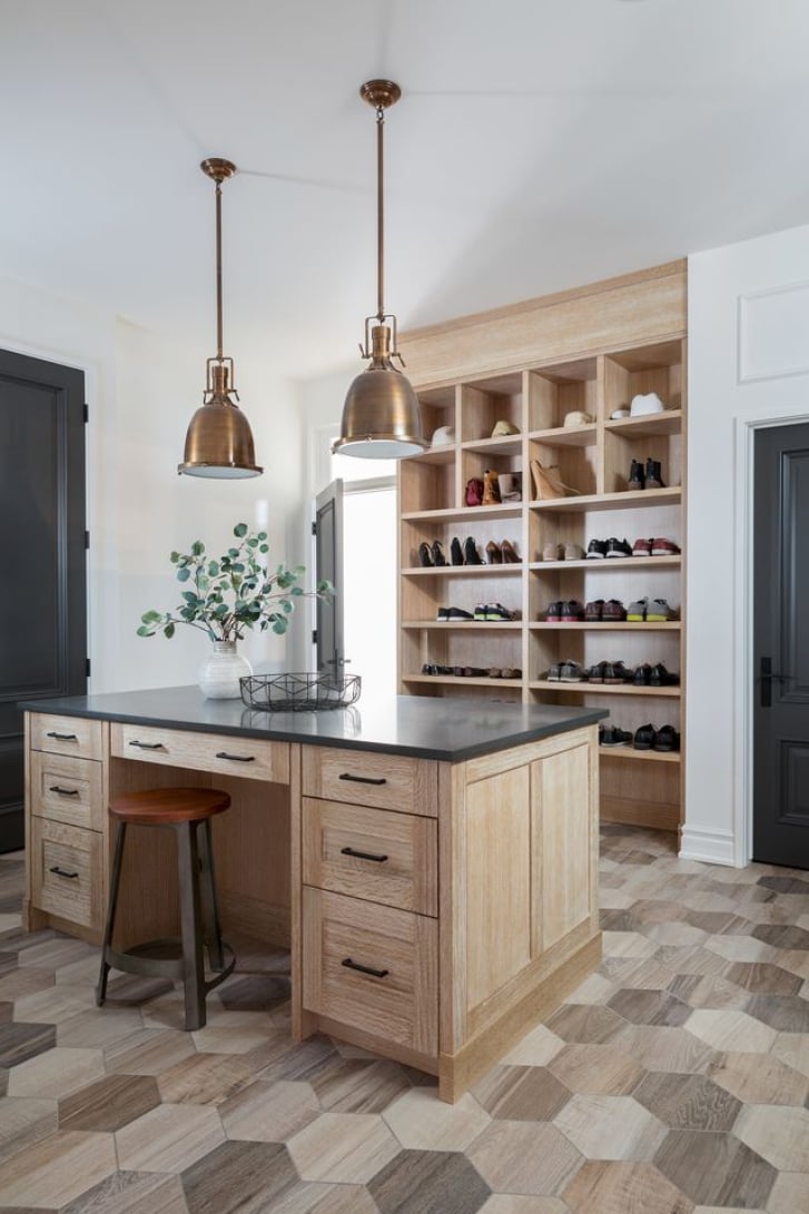 Spacious Calgary mudroom by Nyla Free Designs with a large oak storage island and porcelain tile flooring