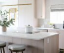 a kitchen with light coloured cabinets awash in natural light